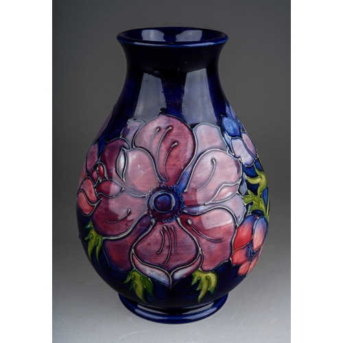 626 - A boxed Moorcroft pottery squat baluster vase decorated in the Anemone design on a dark blue ground,... 