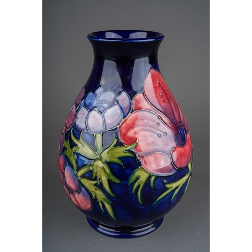 626 - A boxed Moorcroft pottery squat baluster vase decorated in the Anemone design on a dark blue ground,... 