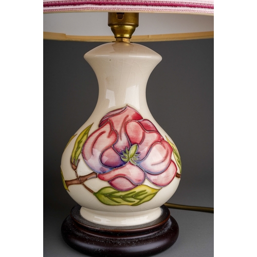 631 - Two Moorcroft pottery baluster table lamps decorated in a Magnolia design on an ivory ground, one wi... 