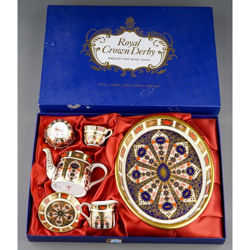 637 - A boxed Royal Crown Derby Imari 1128 pattern miniature five piece tea set and oval tray, the tea set... 