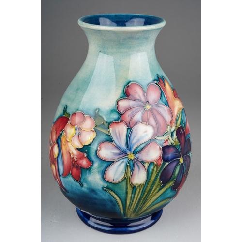 646 - A William Moorcroft pottery baluster vase decorated in the Spring Flowers design, painted signature ... 