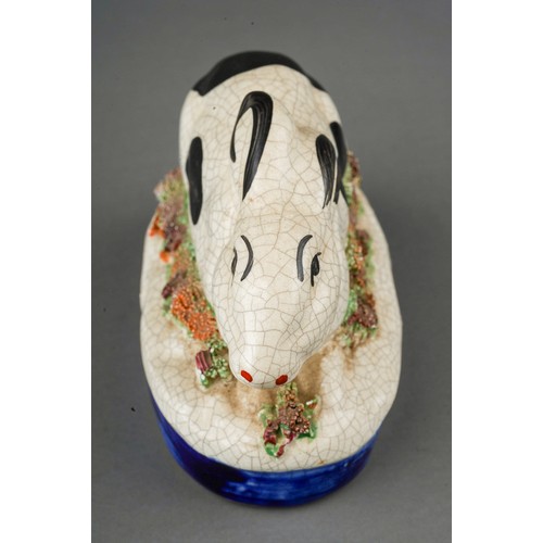 656 - A Staffordshire model of a crouching black and white rabbit on oval raised gilt heightened base, boc... 