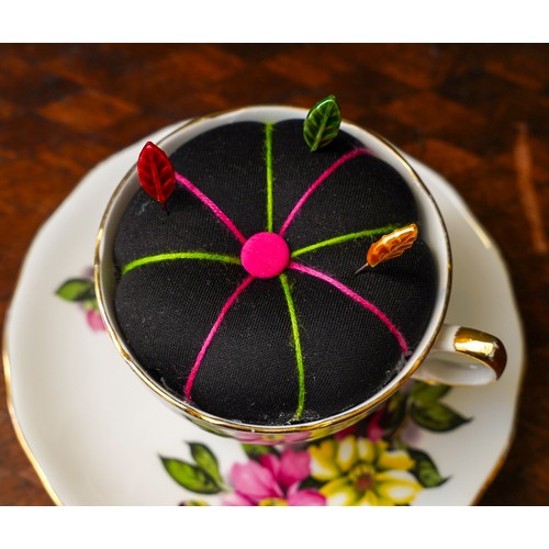 774 - A teacup pin cushion made from the fabric of Lorraine Stanley’s bra and a China cup and saucer.
Appr... 