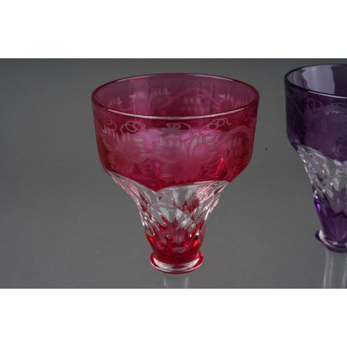 792 - Three John Walsh coloured crystal ogee shaped wine glass with vine leaf and grapes etched border, 2 ... 