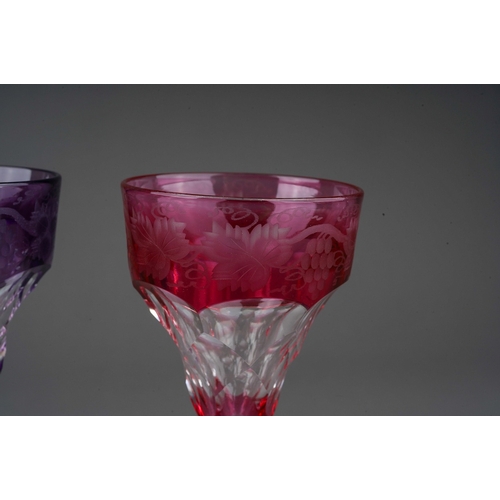 792 - Three John Walsh coloured crystal ogee shaped wine glass with vine leaf and grapes etched border, 2 ... 