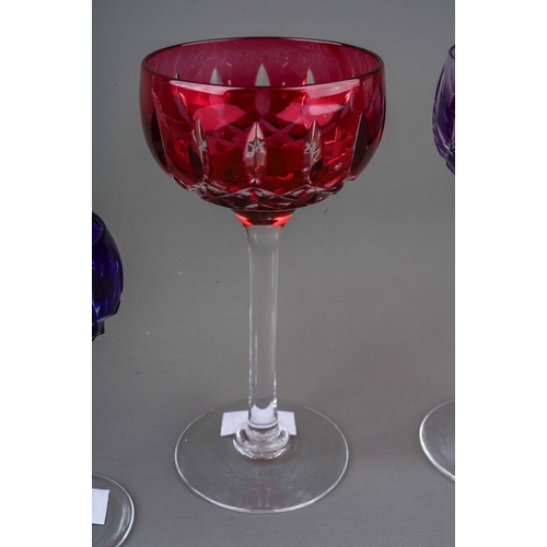 793 - Four John Walsh coloured cut glass wine and port glasses, amethyst, ruby x 2 and cobalt) on clear st... 