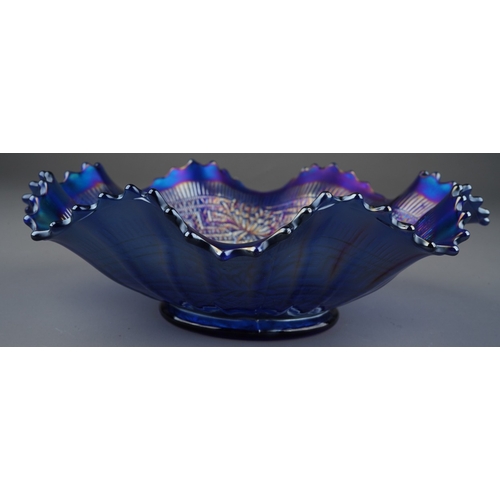 809 - An early 20th century American blue carnival glass wavy rimmed bowl, by Northwood, decorated in in t... 