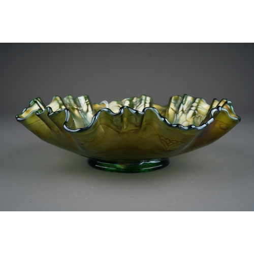 811 - An early 19th century American green Carnival glass wavy rimmed bowl, by Fenton, decorated to the in... 