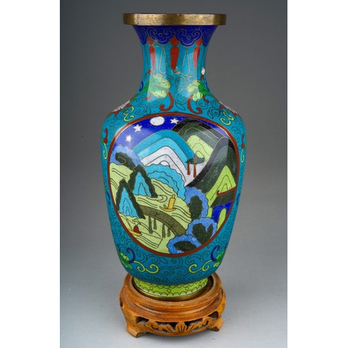 893 - A Japanese Cloisonne baluster vase decorated with stylised mountain scape, on carved wooden base