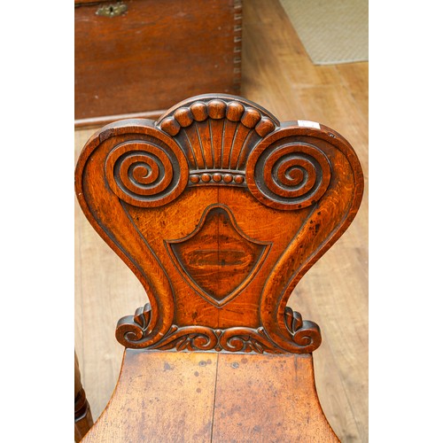 975 - A pair of Victorian oak hall chairs, the cartouche shaped back carved with coronet and scroll style ... 