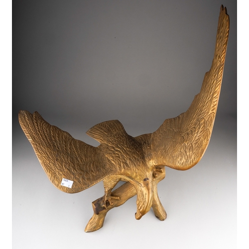 182 - A brass figure of an eagle with outstretched wing, modelled as perched on a branch, width 50cm x hei... 