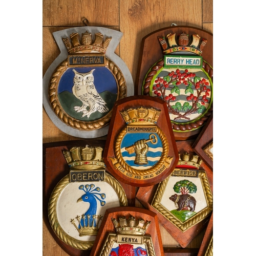 183 - A collection of twelve Royal Navy ships crest relief moulded painted plaster plaques mounted on wood... 