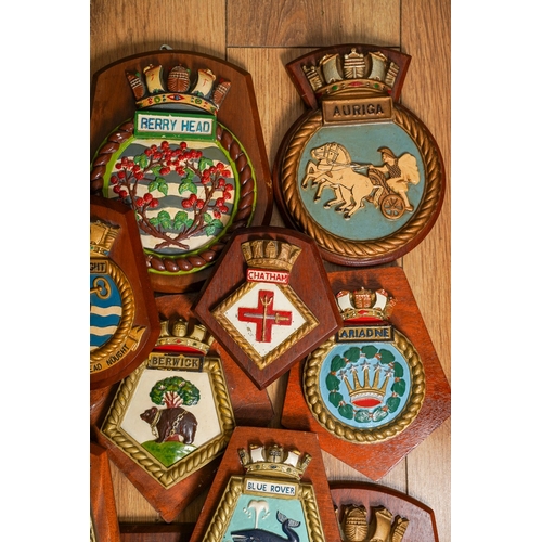 183 - A collection of twelve Royal Navy ships crest relief moulded painted plaster plaques mounted on wood... 