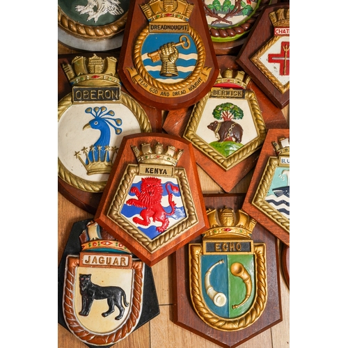 183 - A collection of twelve Royal Navy ships crest relief moulded painted plaster plaques mounted on wood... 