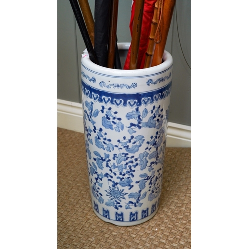 234 - A modern ceramic stick stand containing four umbrellas, six walking sticks and a crop, two of the wa... 