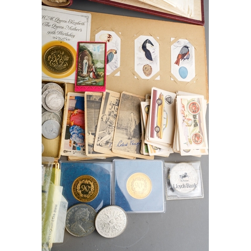 311 - A collection of British and World coins, two British banknotes, stamps and trade cards in albums and... 