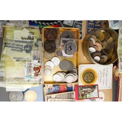 311 - A collection of British and World coins, two British banknotes, stamps and trade cards in albums and... 