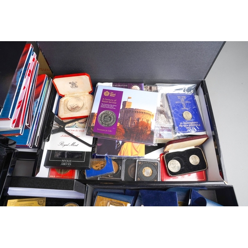 323 - A box of modern commemorative coins, empty coin boxes and packs