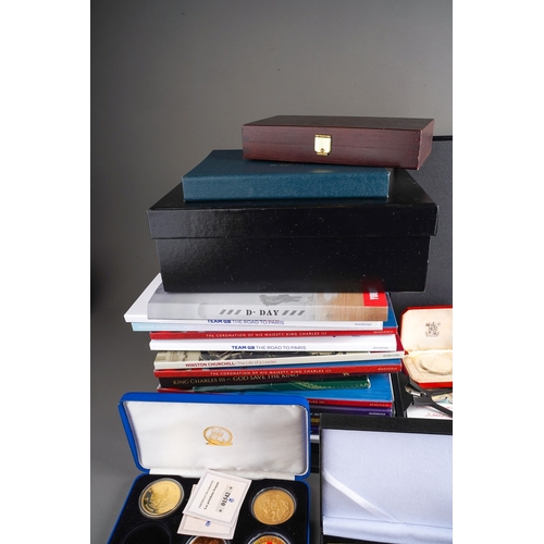 323 - A box of modern commemorative coins, empty coin boxes and packs