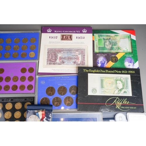 327 - A box of eleven GB coin sets, bank notes, Royal commemorative medallions, two 1 troy oz ingots of .9... 