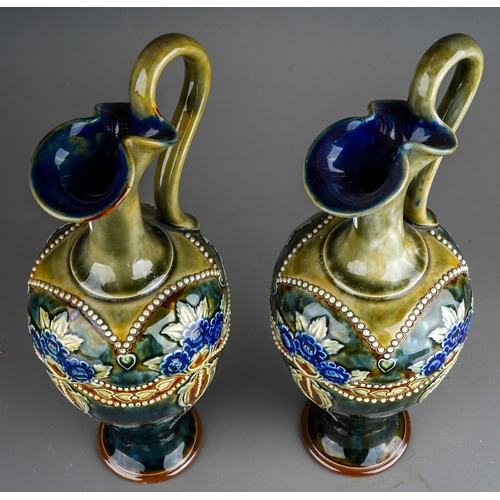 379 - A pair of Royal Doulton stoneware ewers, each on a mottled blue/green ground with glazed floral and ... 