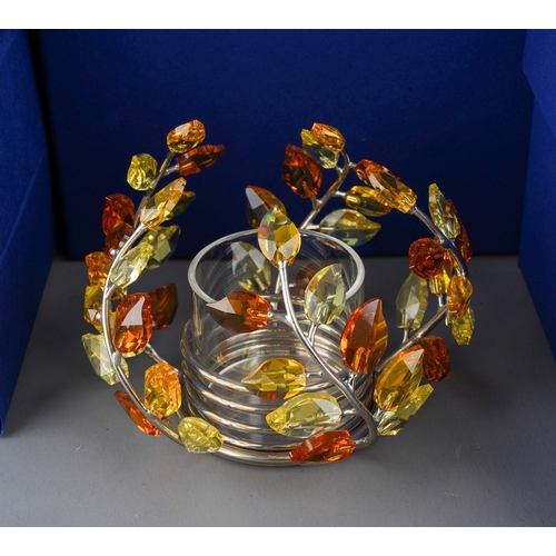 448 - Collection of boxed Swarovski crystal pieces to include a Topaz leaves tea light, dragon on stand, s... 