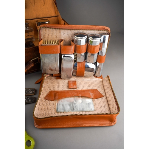 479 - An Art Deco style chrome mounted travelling set in leather case including two brushes with talc, soa... 