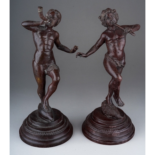 496 - A pair of early 20th Century bronze figures of Classical figures playing pipes (Pan) on raised integ... 