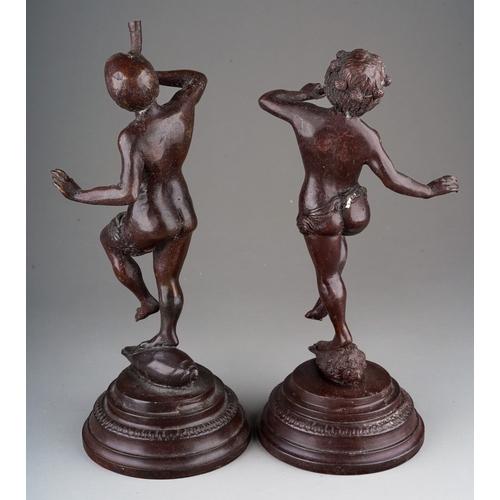 496 - A pair of early 20th Century bronze figures of Classical figures playing pipes (Pan) on raised integ... 