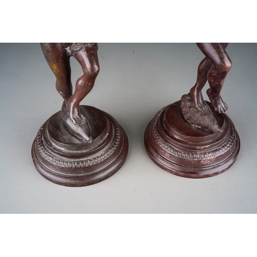 496 - A pair of early 20th Century bronze figures of Classical figures playing pipes (Pan) on raised integ... 