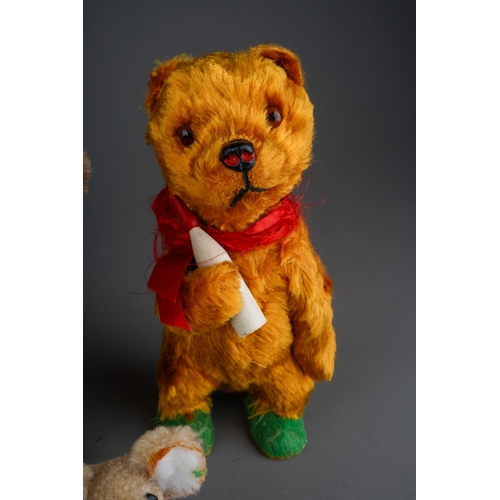 527 - A vintage German possibly Steiff small clockwork plush Bear with red ribbon and holding a bottle, la... 