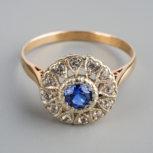 577 - A mid 20th century cluster ring. Set with a blue synthetic blue spinel, surrounded by colourless syn... 