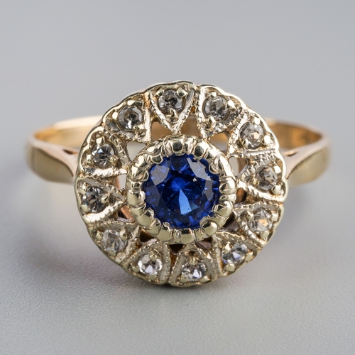 577 - A mid 20th century cluster ring. Set with a blue synthetic blue spinel, surrounded by colourless syn... 