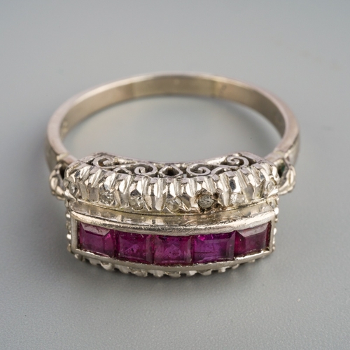 578 - A ruby and diamond dress ring. Set with a line of square shape rubies, surrounded by single cut diam... 