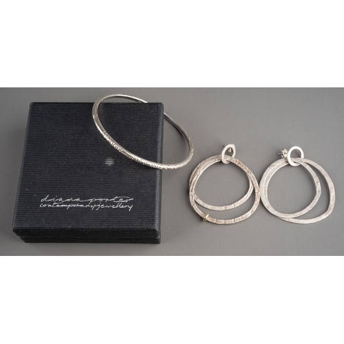 592 - A Diana Porter silver earrings and a bangle. The hallmarked silver by the Bristol jewellery designer... 