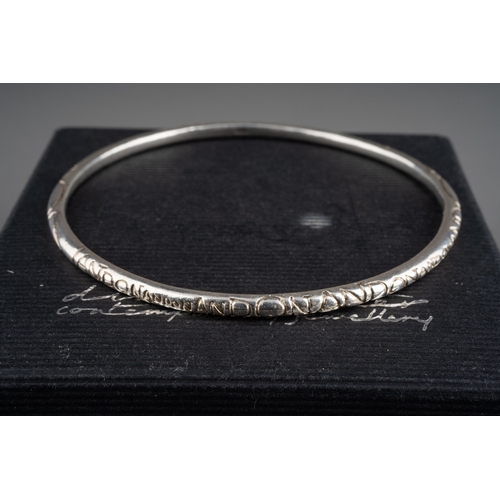 592 - A Diana Porter silver earrings and a bangle. The hallmarked silver by the Bristol jewellery designer... 