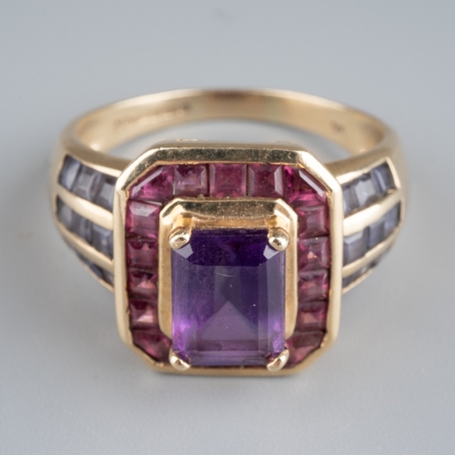 607 - A 9ct gold gem set dress ring. Set with a central amethyst, surrounded by pink gemstones and purple ... 