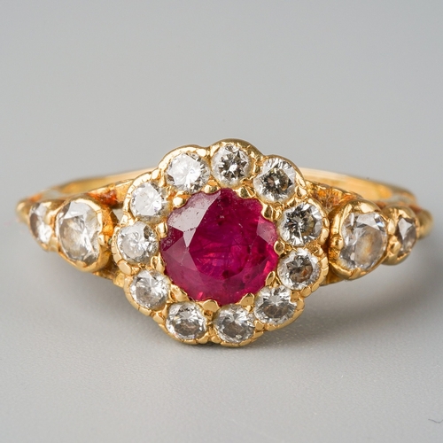 663 - A modern ruby and diamond cluster ring. Set with a central ruby, surrounded by round brilliant cut d... 