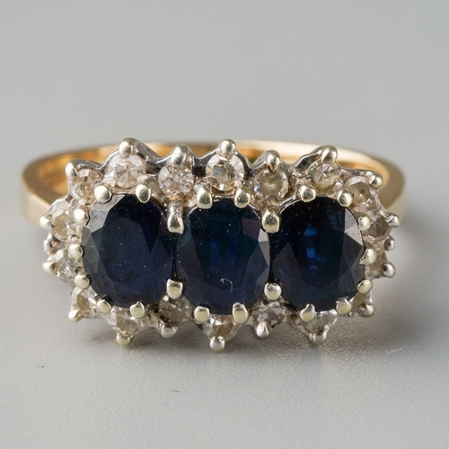 665 - A sapphire and diamond dress ring. Set with three oval shape sapphires surrounded by single cut diam... 