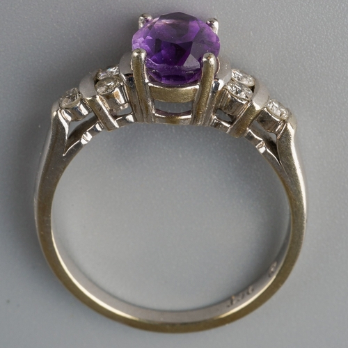 666 - A 9ct white gold amethyst and diamond dress ring. Set with a central oval shape amethyst, with round... 