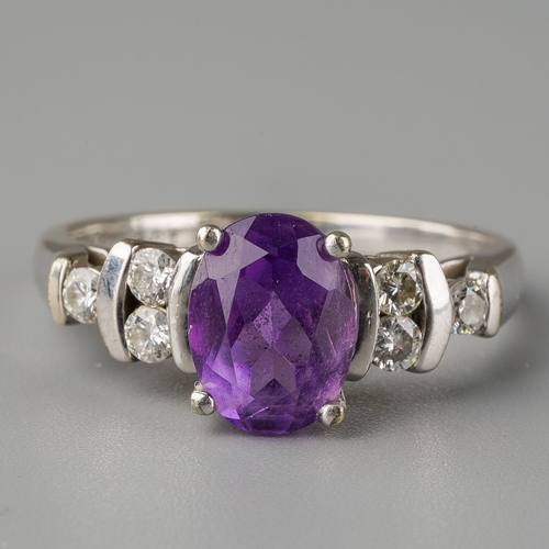 666 - A 9ct white gold amethyst and diamond dress ring. Set with a central oval shape amethyst, with round... 