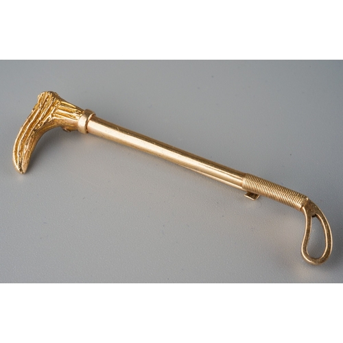 669 - A 9ct gold bar brooch. Designed as a riding crop brooch. Hallmaked 9ct gold Birmingham 1984, approx ... 