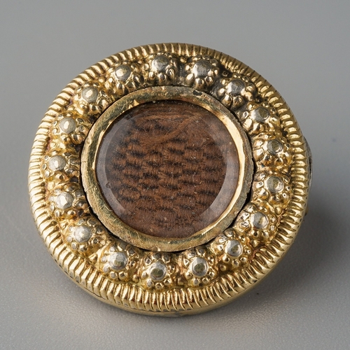 670 - A late 19th century mourning brooch. The central woven hair panel within beaded border and grooved s... 