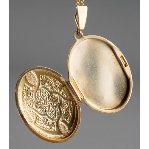 672 - A 9ct gold locket with chain. The oval locket with scroll embossed front, suspended from a flat curb... 