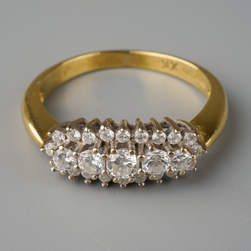 676 - An 18ct gold diamond dress ring. Set with five graduating round brilliant cut diamonds, within a rou... 