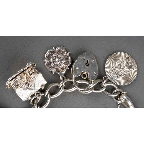 692 - A 20th century silver charm bracelet, with heart padlock and ten attached charms, gross weight 1.79o... 