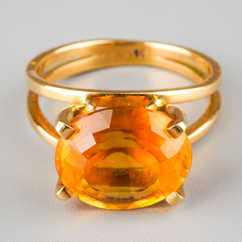 717 - A modern citrine dress ring. Set with an oval shape mixed cut citrine, four claw set, to the split s... 