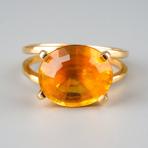 717 - A modern citrine dress ring. Set with an oval shape mixed cut citrine, four claw set, to the split s... 