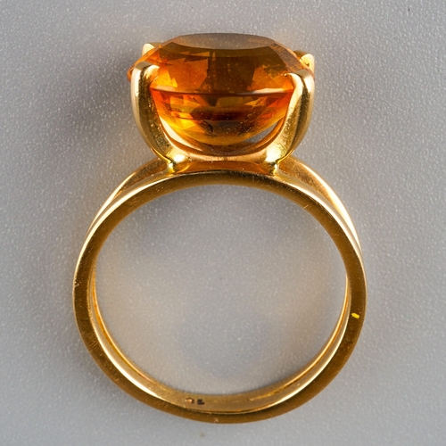 717 - A modern citrine dress ring. Set with an oval shape mixed cut citrine, four claw set, to the split s... 