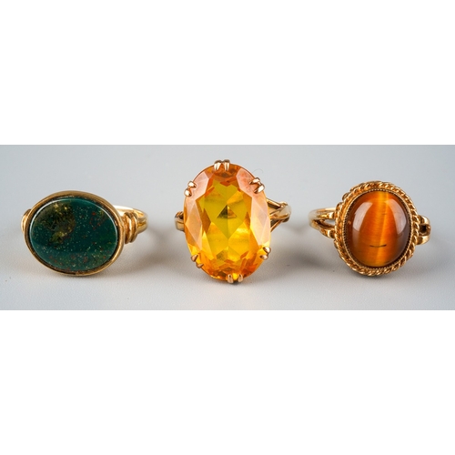 718 - Three gem set rings. To include a yellow synthetic sapphire single stone ring, stamped 9ct, together... 